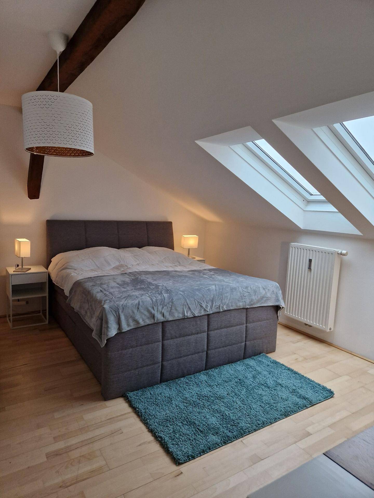 Helles Schlafzimmer im Dachgeschoss mit Doppelbett und Dachfenstern.