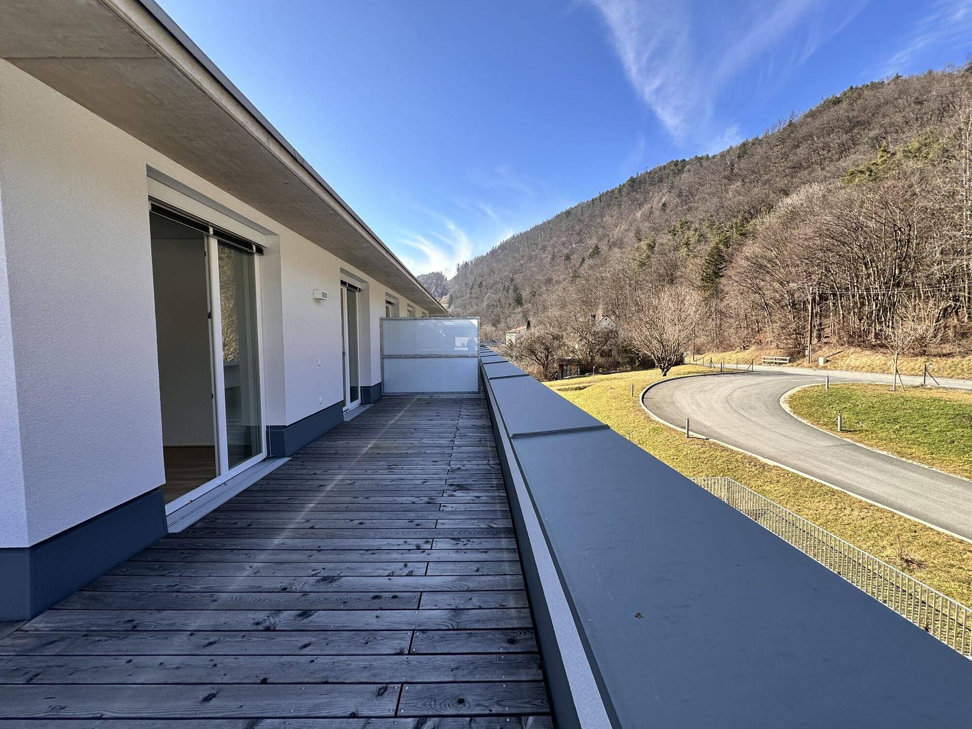 Ausgedehnte Dachterrasse mit Holzboden und Panoramablick auf die bewaldeten Hügel.