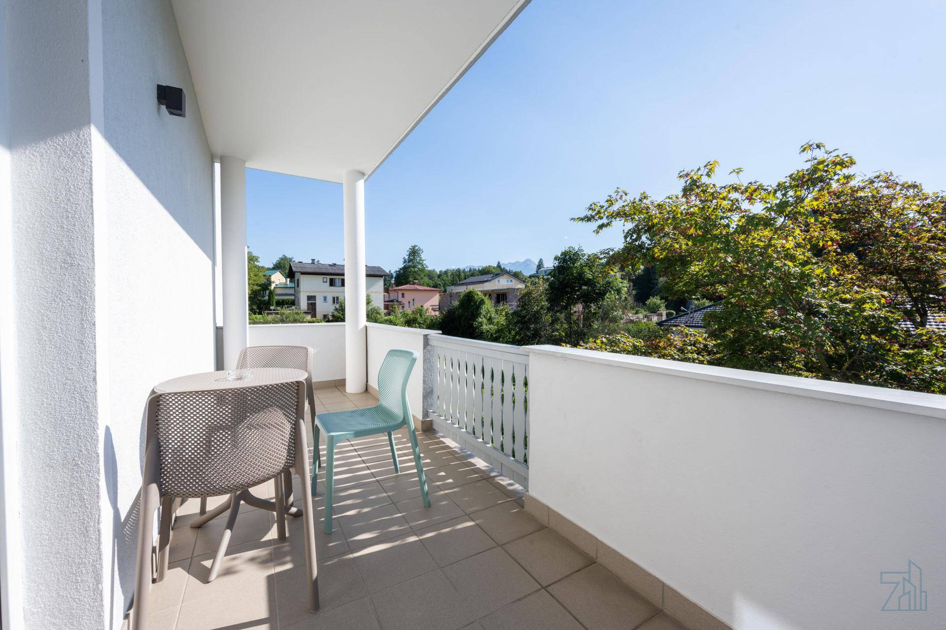 Heller Balkon mit Sitzgelegenheiten und Blick auf die umliegende Wohngegend.