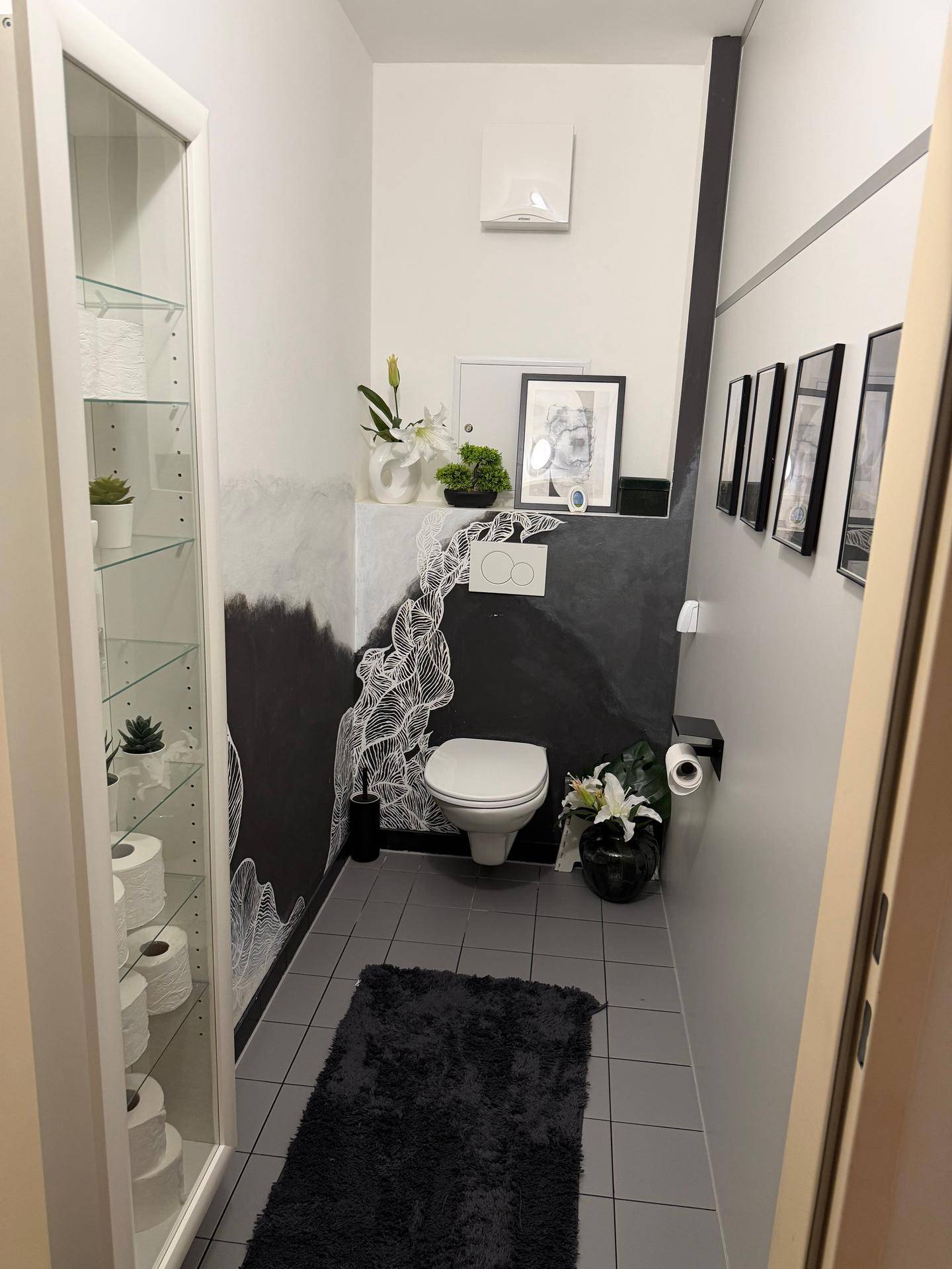 Modernes Gäste-WC mit kreativer Wandgestaltung und Wand-WC.