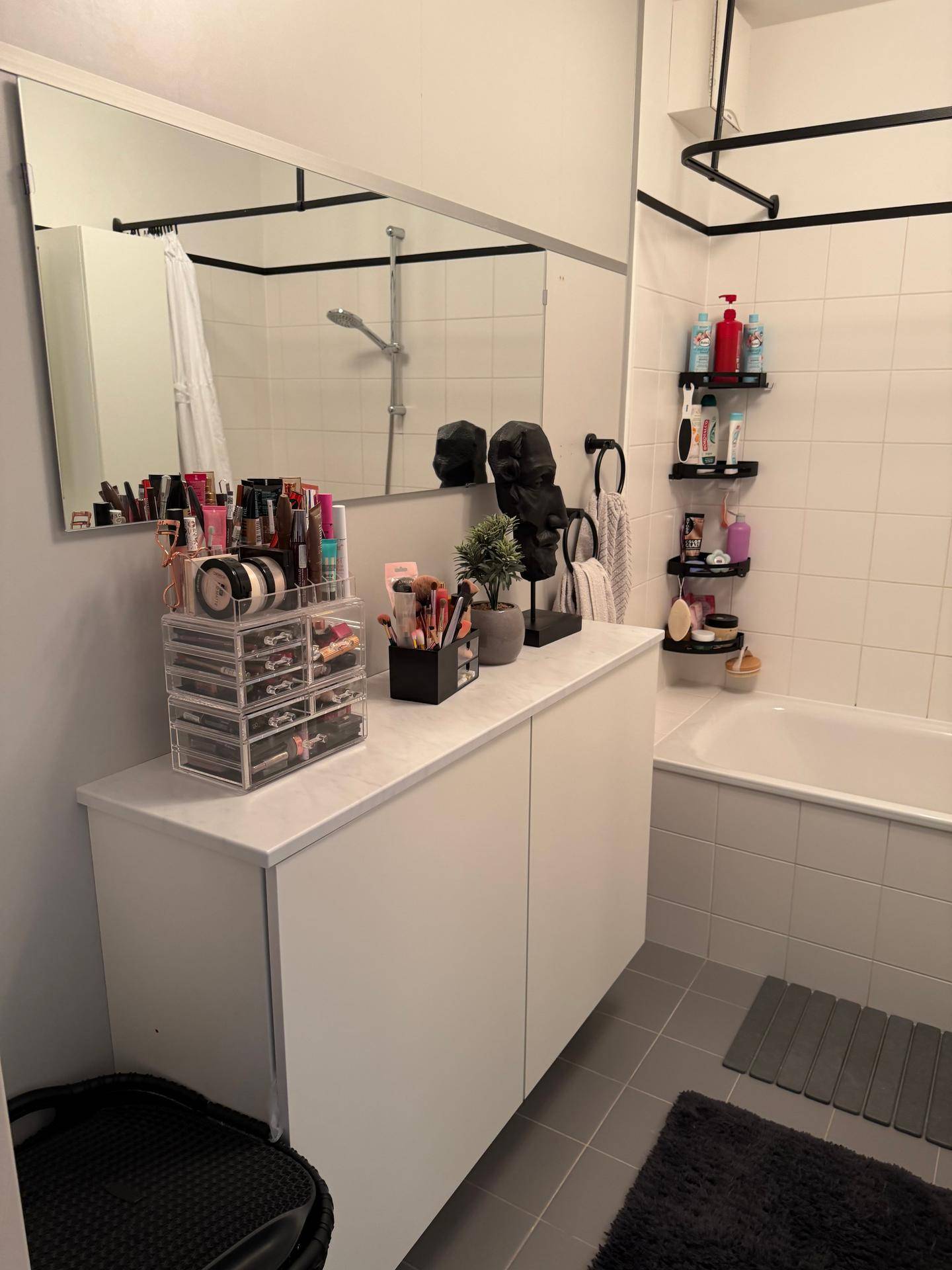 Modernes Badezimmer mit Badewanne, großem Spiegel und praktischem Waschtisch.