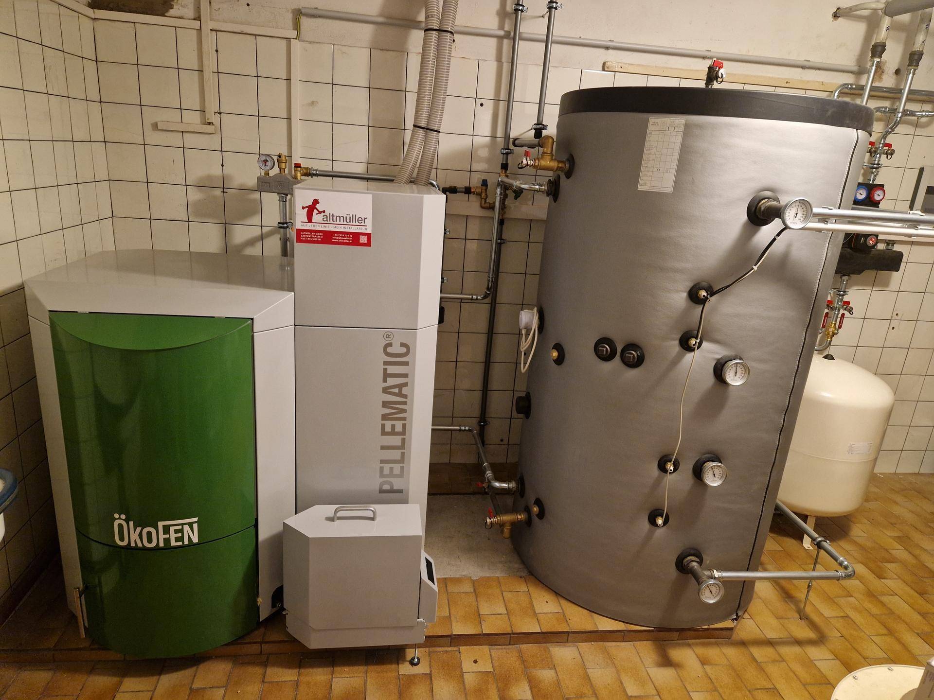Heizungsraum mit moderner Pelletheizung und Warmwasserspeicher, funktional eingerichtet.
