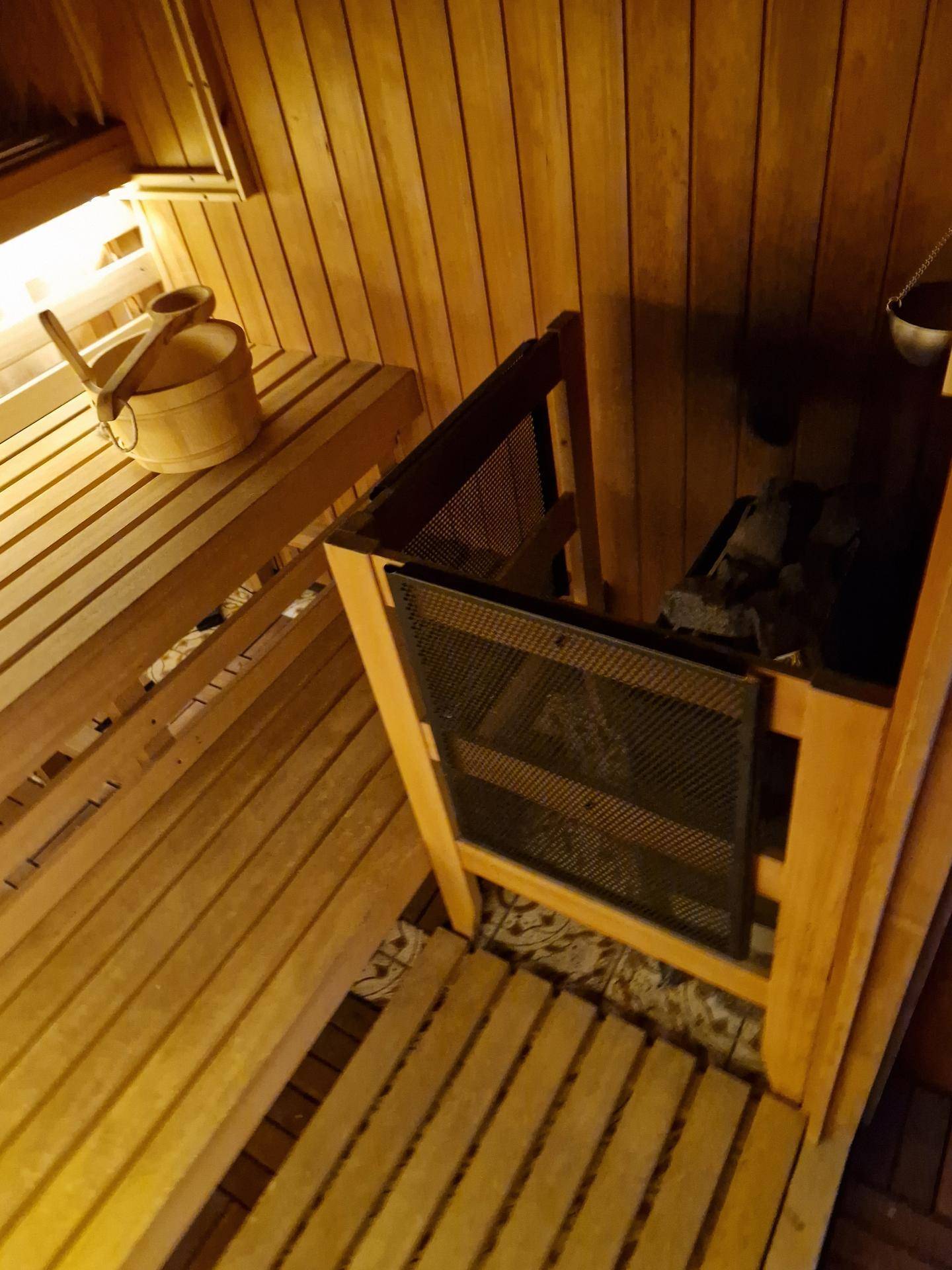 Detailansicht des Saunaofens und der Holzbänke in einer traditionellen Sauna.