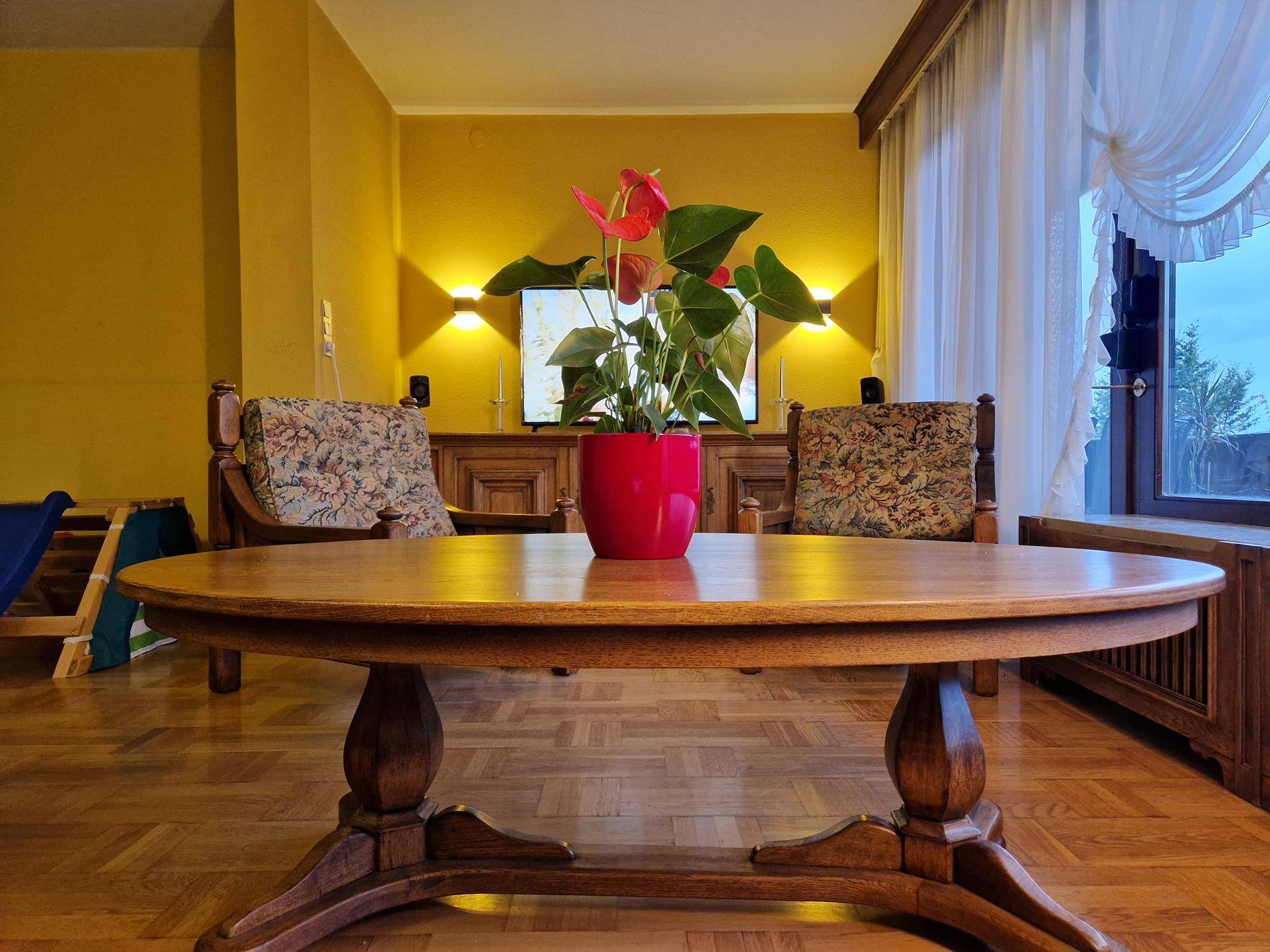 Gemütliches Wohnzimmer mit traditionellen Möbeln, Parkettboden und gelben Wänden.