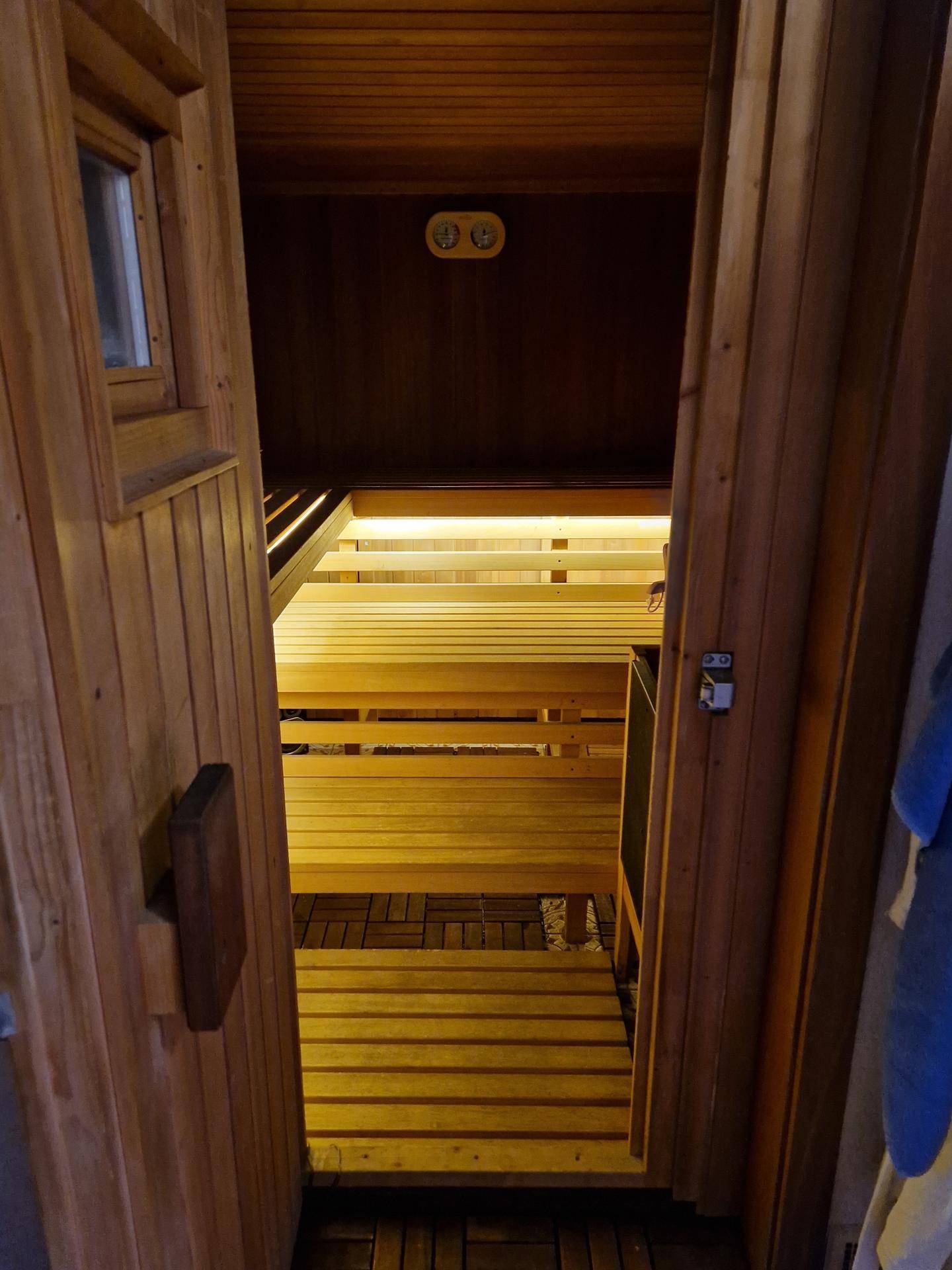 Innenansicht einer Holzsauna mit mehreren Bänken und natürlicher Holzverkleidung.