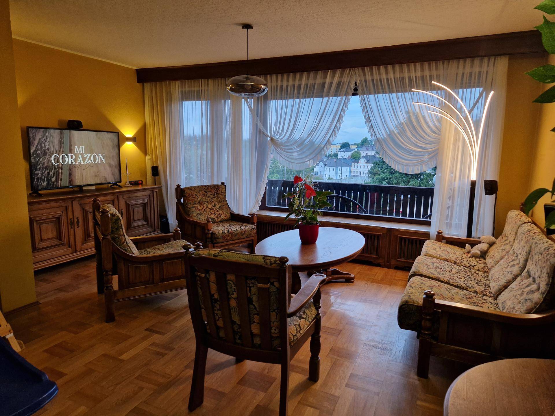 Helles Wohnzimmer mit traditionellen Möbeln, Parkettboden und weitem Blick ins Grüne.