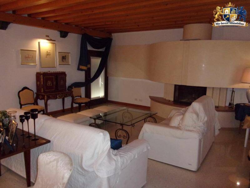Gemütliches Wohnzimmer mit Holzbalkendecke, bequemen Sofas und einem großen Kaminbereich für entspannte Stunden.