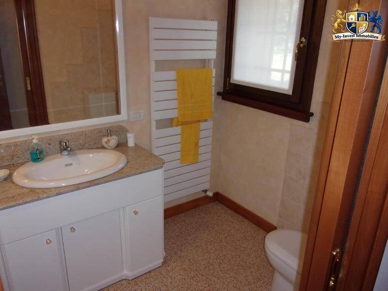 Modernes Badezimmer mit Einzelwaschbecken, Granit-Arbeitsplatte, Fenster und beheiztem Handtuchhalter.