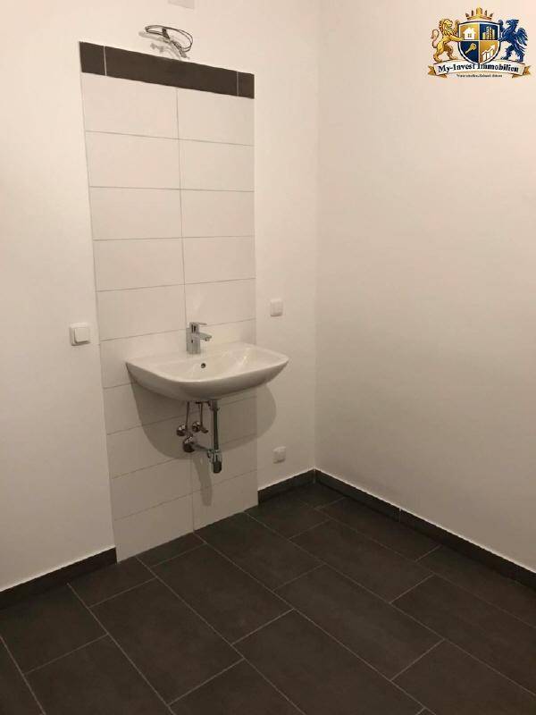 Kleines Badezimmer oder Gäste-WC mit modernem Waschbecken und dunklen Bodenfliesen.