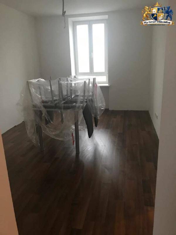 Heller Essbereich mit dunklem Laminatboden und einem Fenster, vorbereitet für die Nutzung.
