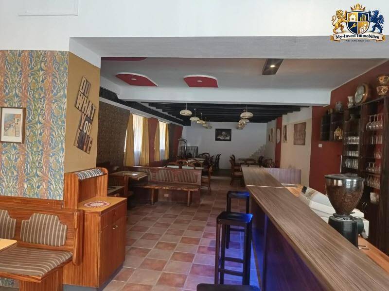 Großer Essbereich mit Bar, Holzbänken und gemusterten Fliesenböden.