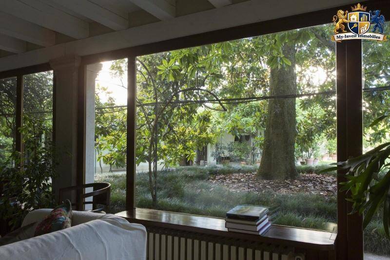 Gemütliches Wohnzimmer mit großen Panoramafenstern, die einen direkten Blick in den grünen Garten bieten.