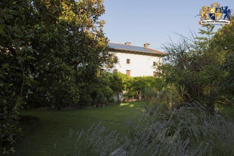 Rückansicht des Hauses mit großem Garten, Rasenfläche und Photovoltaikanlage auf dem Dach.