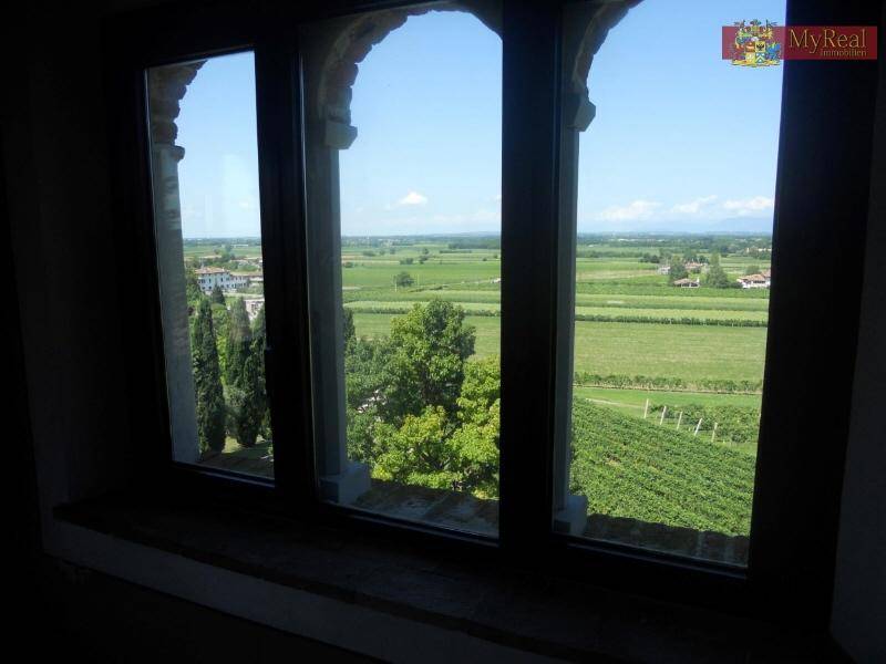 Weitläufiger Ausblick aus einem Bogenfenster über Weinberge und die weite Landschaft.