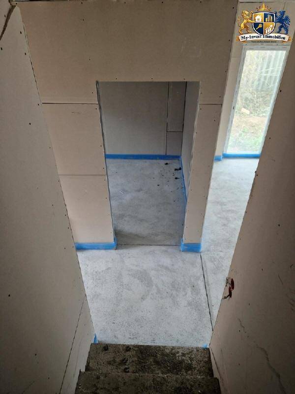Unfertiger Treppenbereich im Rohbau mit Betonstufen und Trockenbauwänden, bereit für den Ausbau.