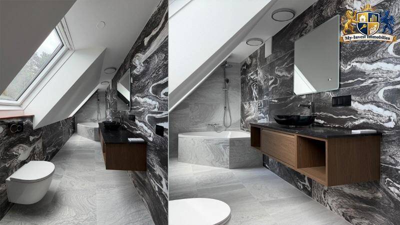 Modernes Badezimmer mit dunklen Marmorfliesen, freistehender Badewanne und Dachfenster unter Schrägdach.