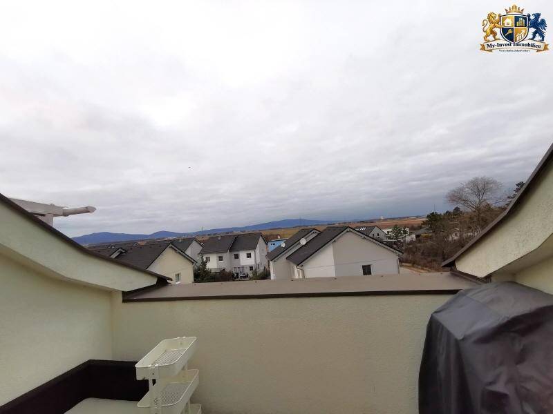 Weitläufige Dachterrasse mit Panoramablick auf die umliegende Wohnsiedlung und die Berge.