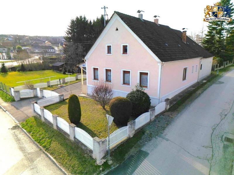 Einfamilienhaus von der Straße aus gesehen mit Vorgarten und angrenzendem Gehweg.