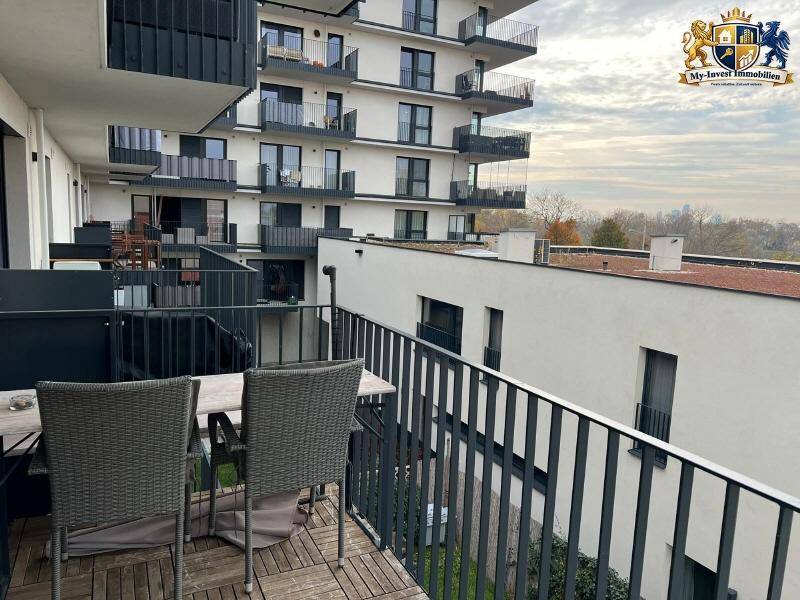 Geräumiger Balkon mit Holzboden und Sitzgelegenheiten, bietet einen weiten Blick über die Umgebung.