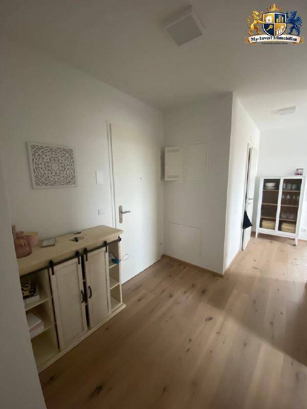 Heller Flur mit Holzboden und modernem Sideboard, führt zu weiteren Räumen der Wohnung.