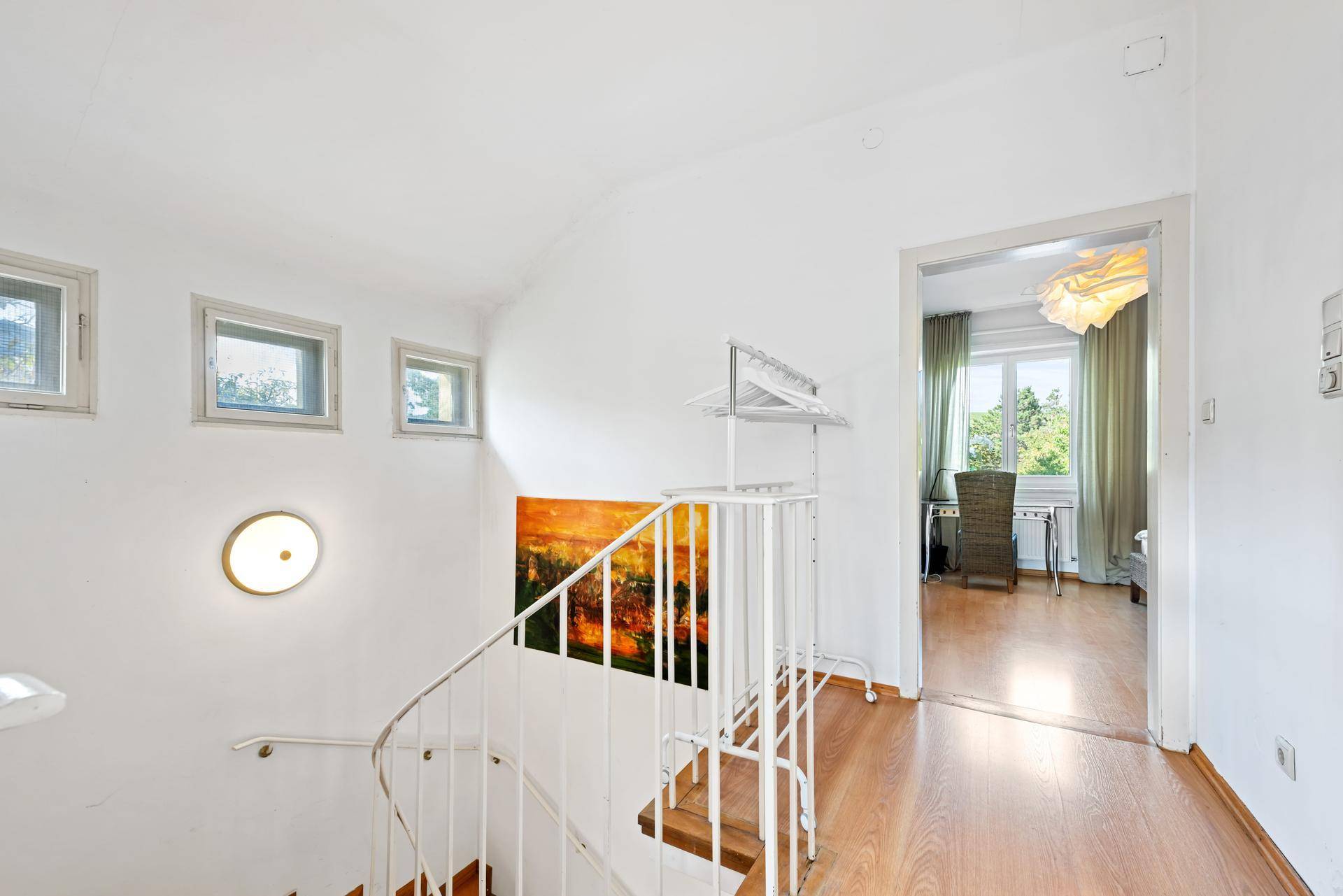 Heller Treppenaufgang mit Holzstufen und Blick in den oberen Wohnbereich.