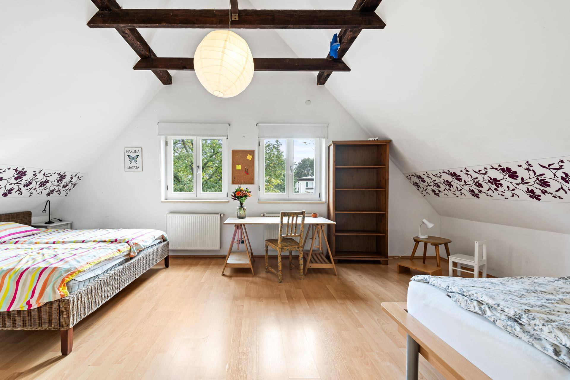 Geräumiges Schlafzimmer im Dachgeschoss mit Holzbalken und zwei Einzelbetten.