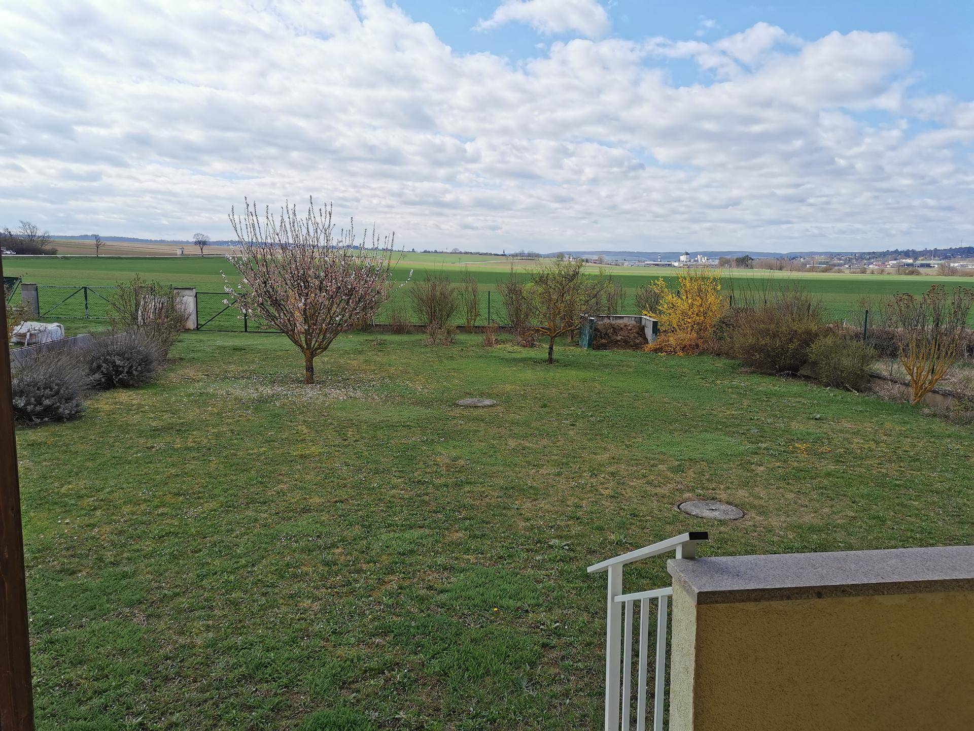 Weitläufiger Garten mit Rasenfläche und Blick auf die umliegende grüne Landschaft.