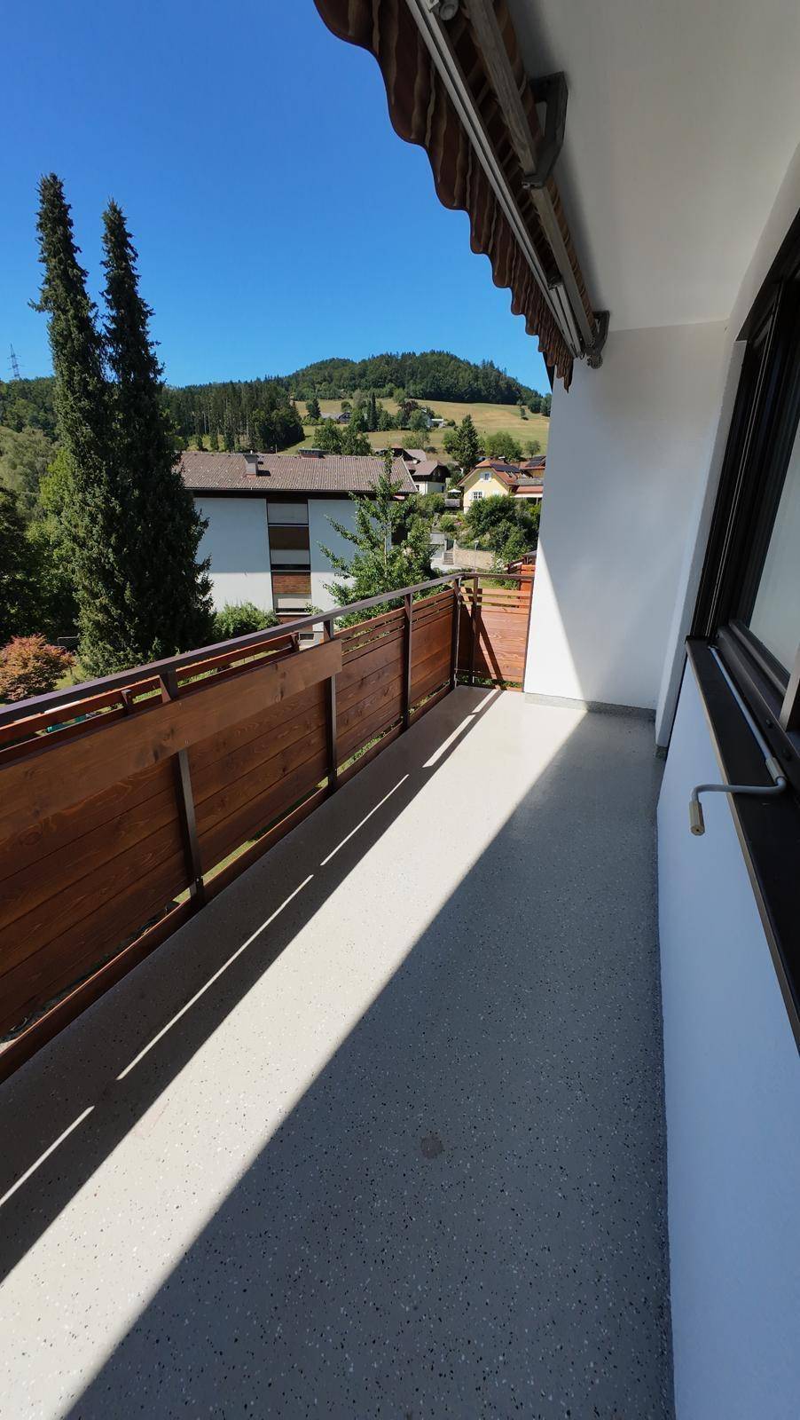 Geräumiger Balkon mit weitem Blick auf grüne Hügel und die Nachbarschaft.