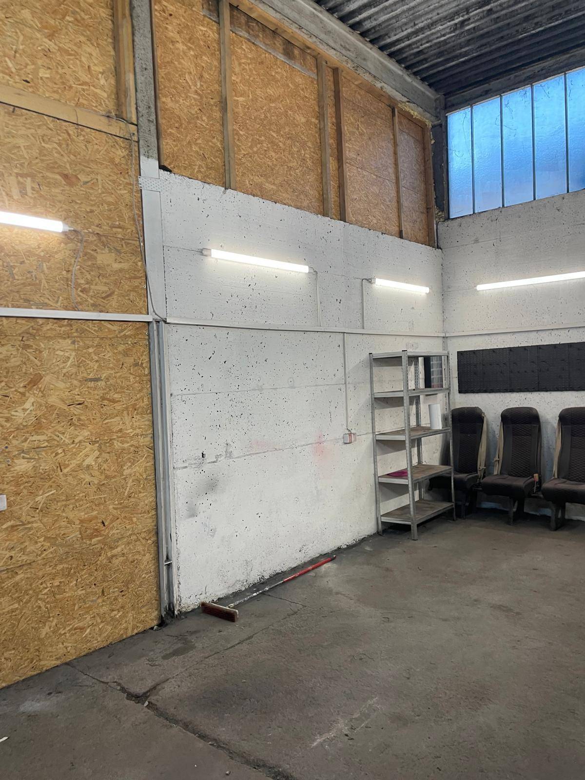 Blick auf die Wände eines Werkstattraums mit OSB-Platten und sichtbarer Betonstruktur.
