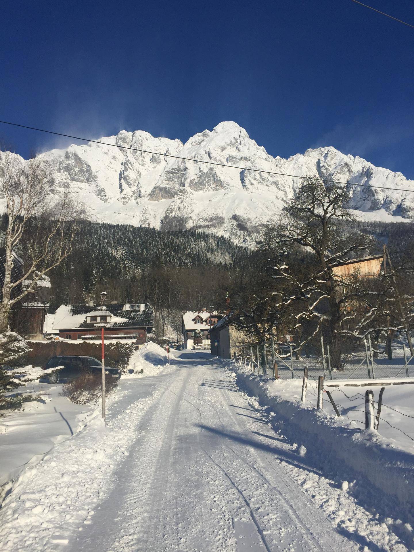 Winterlandschaft mit schneebedeckter Straße, die zu den imposanten Bergen führt.