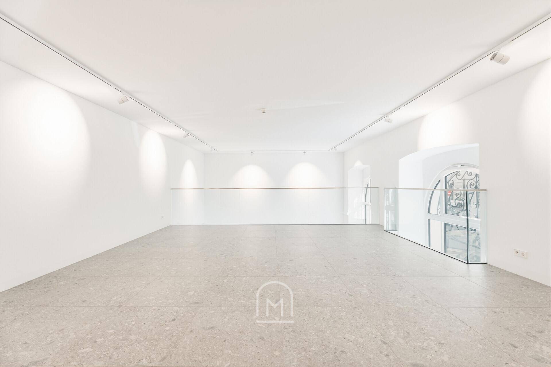 Weitläufige Galeriefläche mit minimalistischem Design und indirekter Beleuchtung.