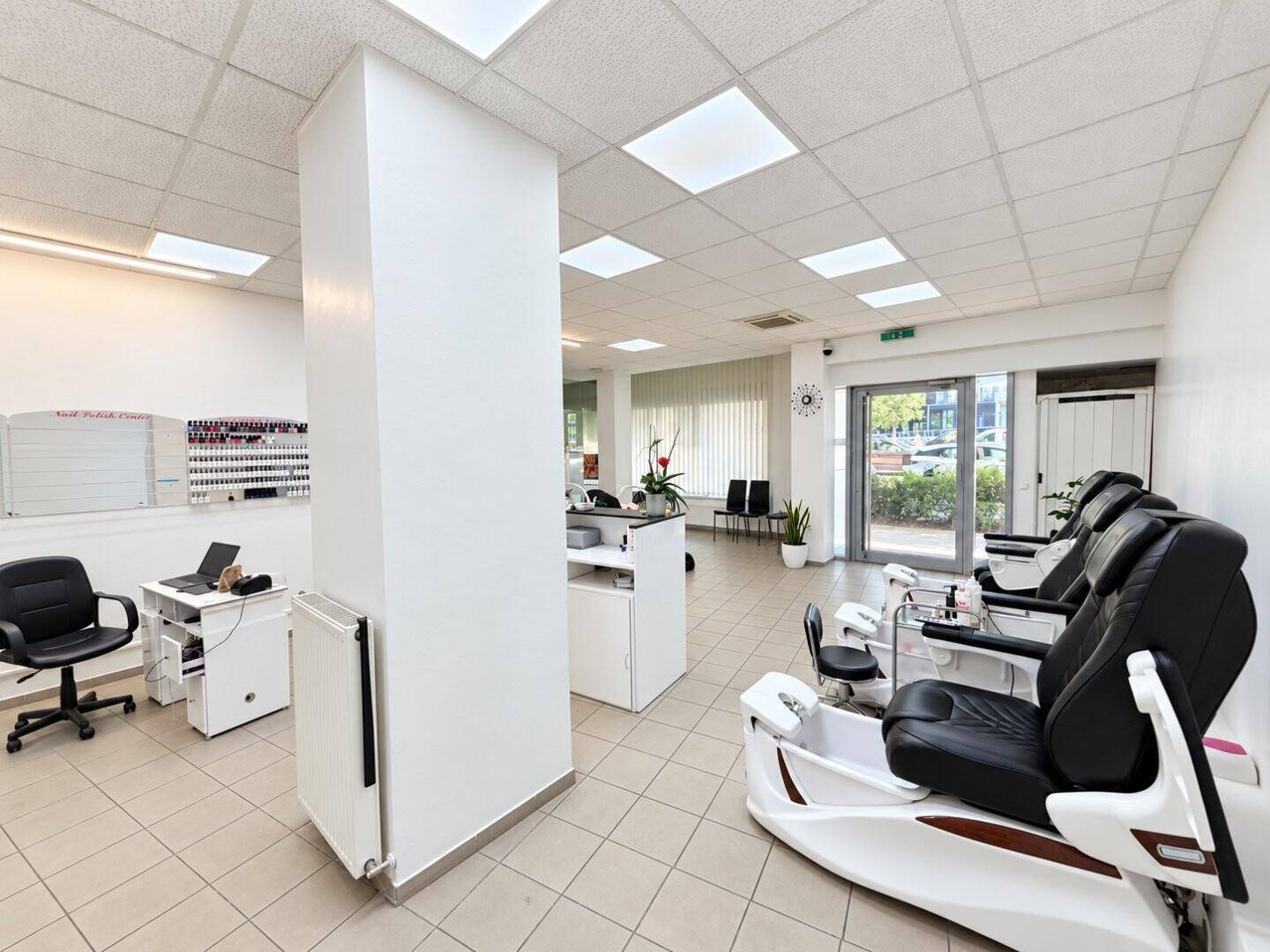 Heller Gewerberaum mit Arbeitsbereichen, Pediküre-Stationen und Blick auf den Eingangsbereich.