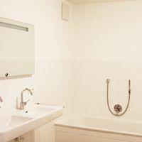 Helles Badezimmer mit Badewanne, Waschbecken und Spiegelschrank.