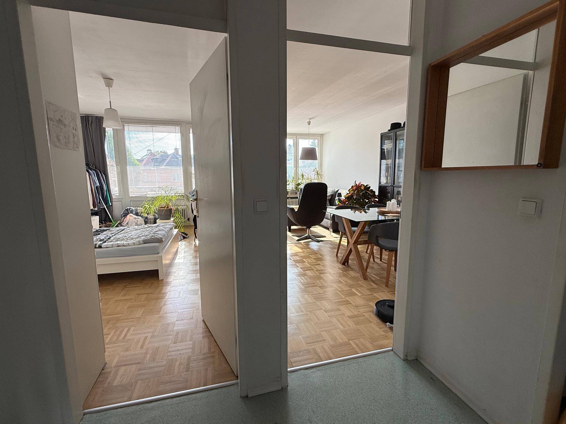 Heller Flur mit Zugang zu Schlafzimmer und Wohnbereich, ausgestattet mit Parkettboden.
