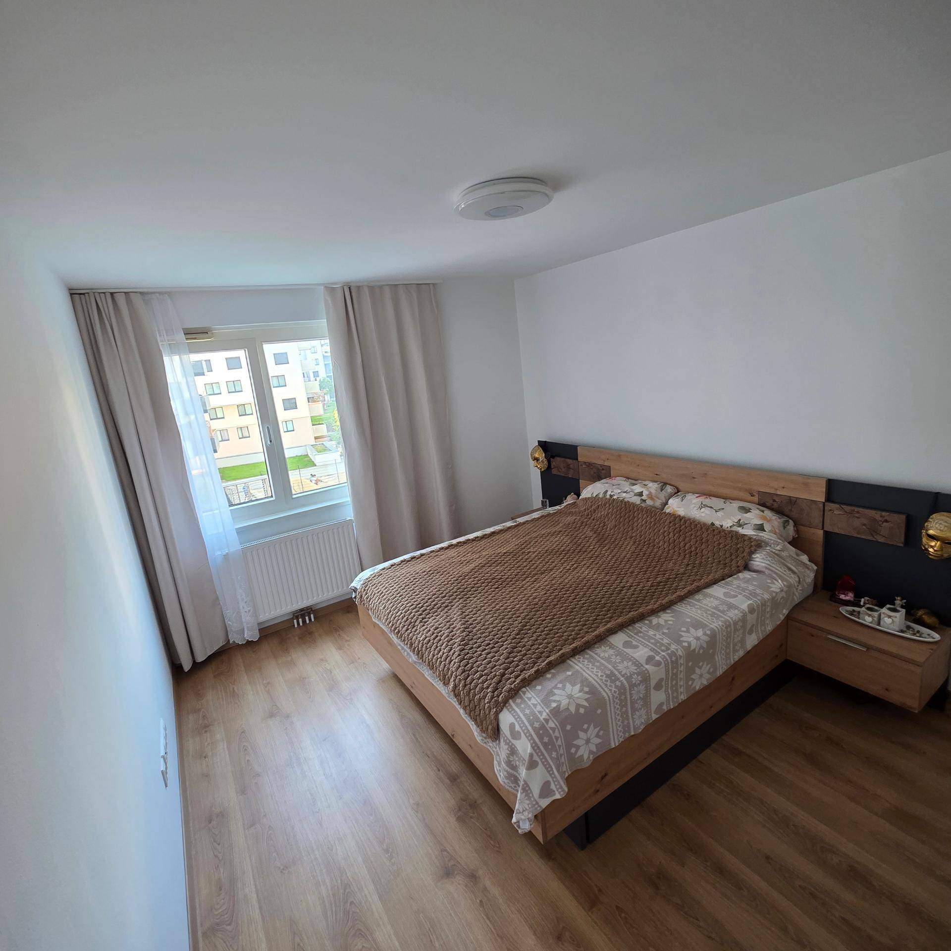 Gemütliches Schlafzimmer mit Doppelbett, Holzfußboden und Nachttischen.