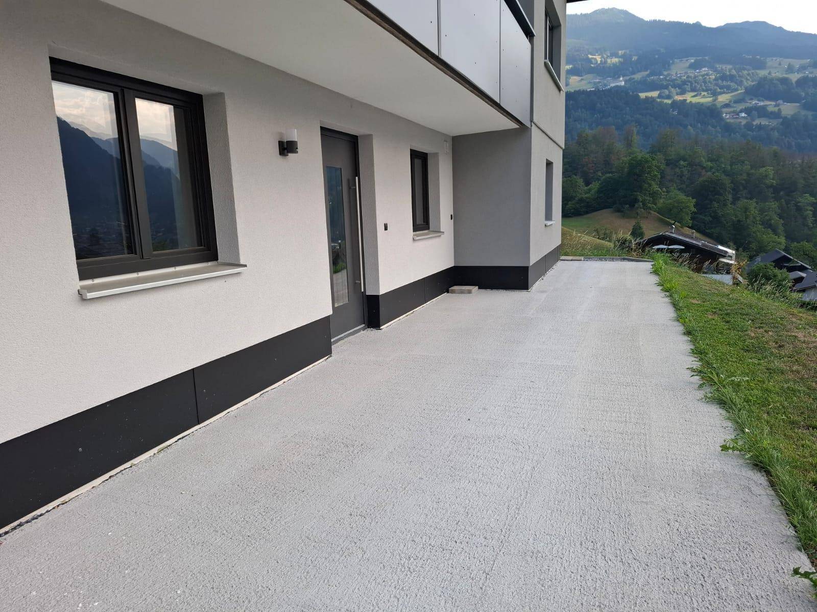 Gepflasterter Bereich neben dem Haus mit Blick auf die umliegende Berglandschaft.