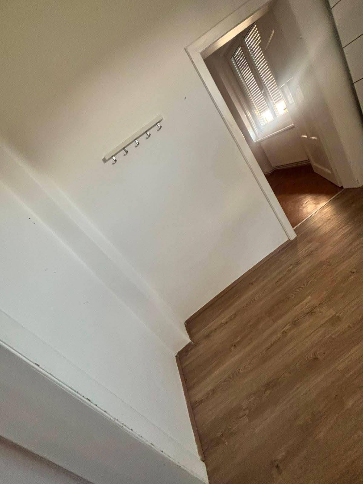 Heller Flur mit Laminatboden und einer Garderobe an der Wand.