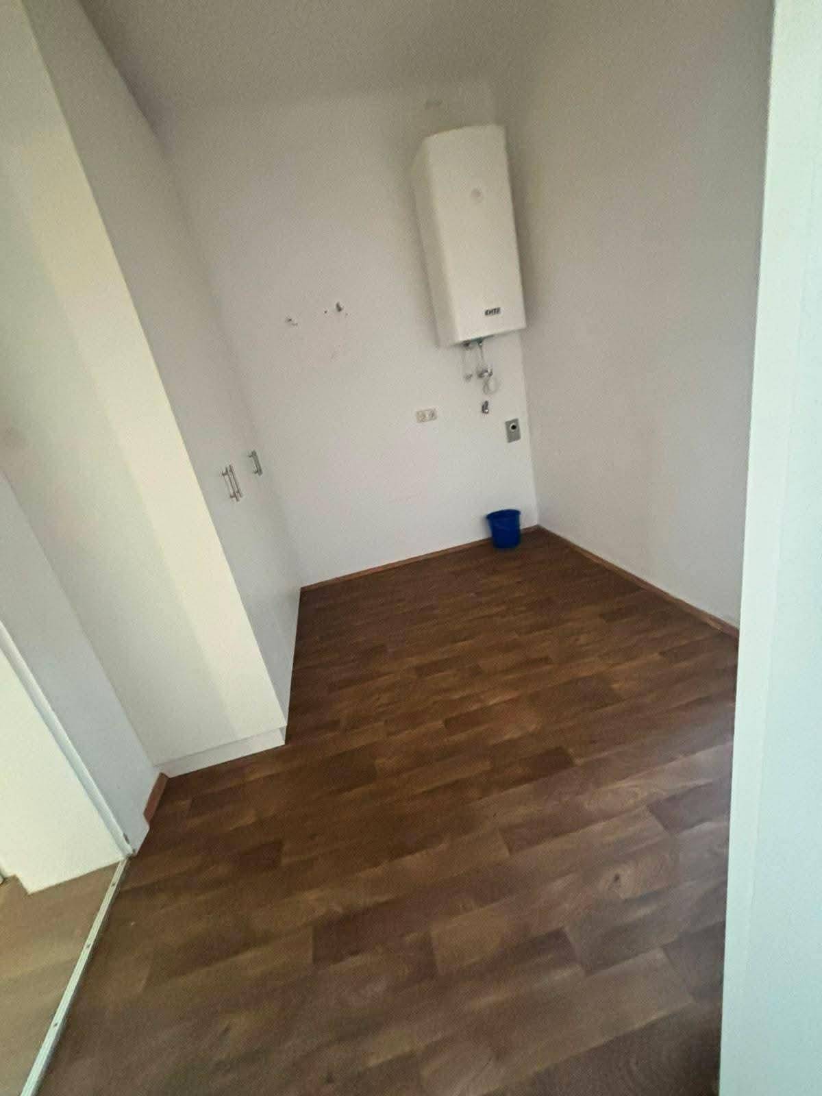 Kleiner Abstellraum mit Warmwasserbereiter und Laminatboden.