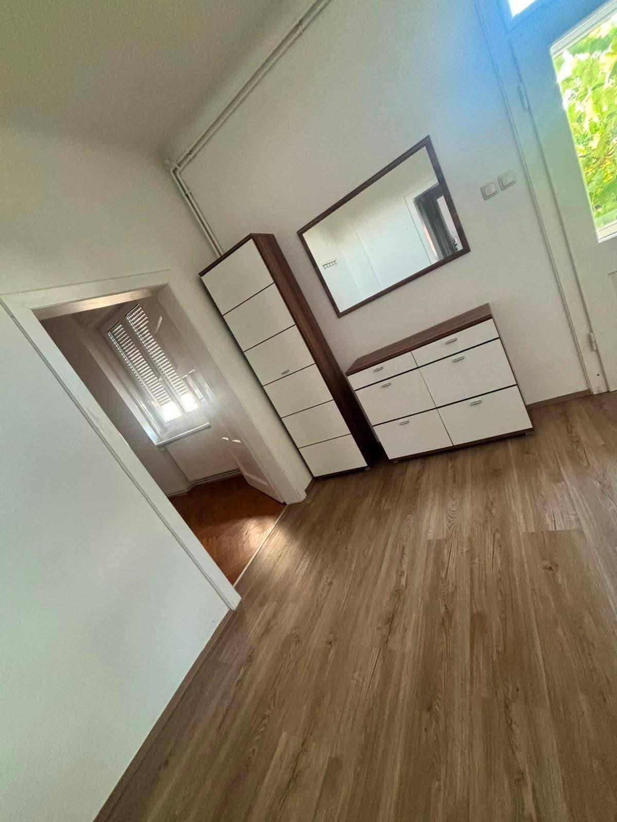 Eingangsbereich mit Laminatboden, Spiegel und praktischen Schuhschränken.