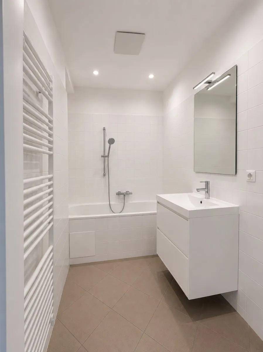 Helles Badezimmer mit Badewanne, modernem Waschtisch und beheiztem Handtuchhalter.