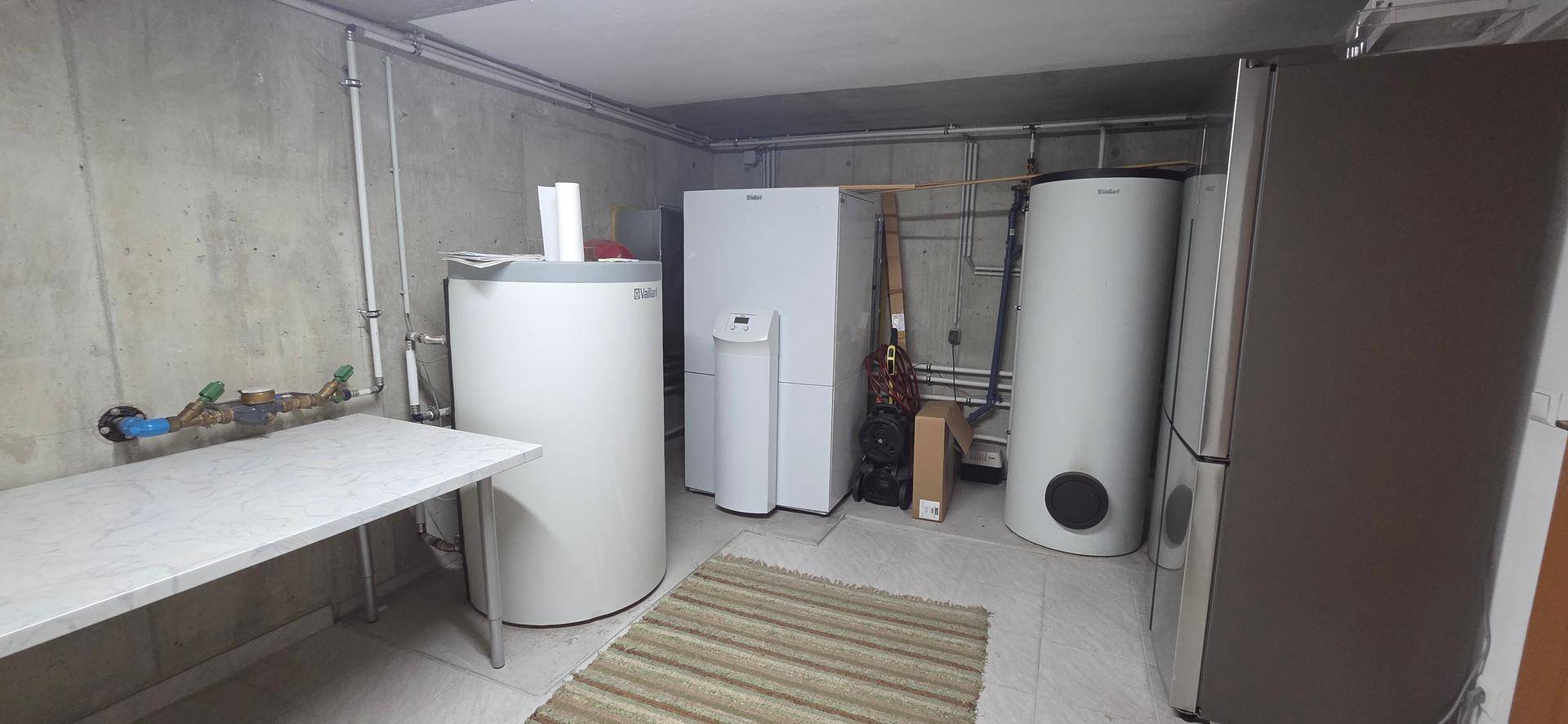 Technikraum im Keller mit Heizungsanlagen und Warmwasserspeichern, funktional eingerichtet.