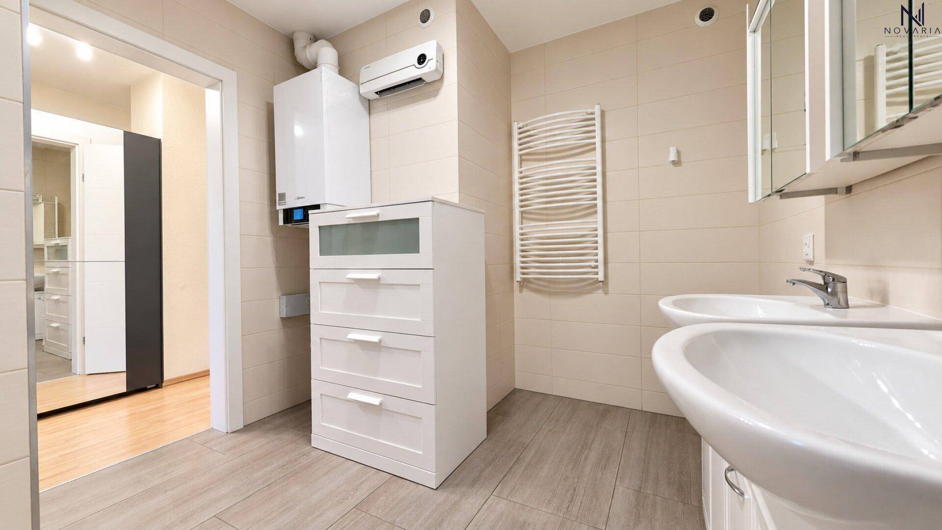 Funktionaler Hauswirtschaftsraum mit Heizungsanlage, zwei Waschbecken und Handtuchheizkörper.