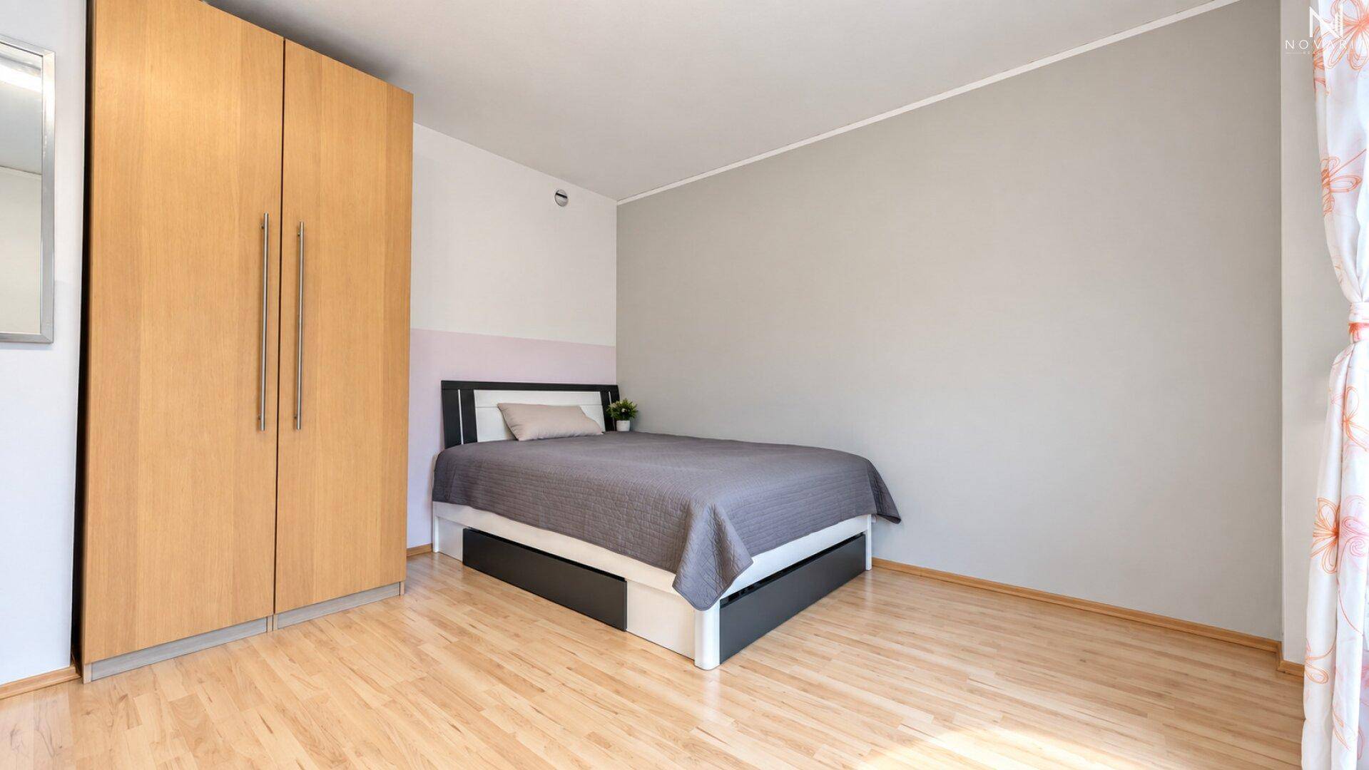 Gemütliches Schlafzimmer mit Doppelbett und großem Holzschrank, hell und freundlich.