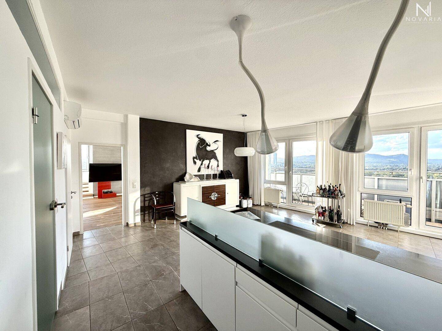 Heller Wohn- und Essbereich mit stilvollem Sideboard, Kunst und Blick auf die umliegende Landschaft.