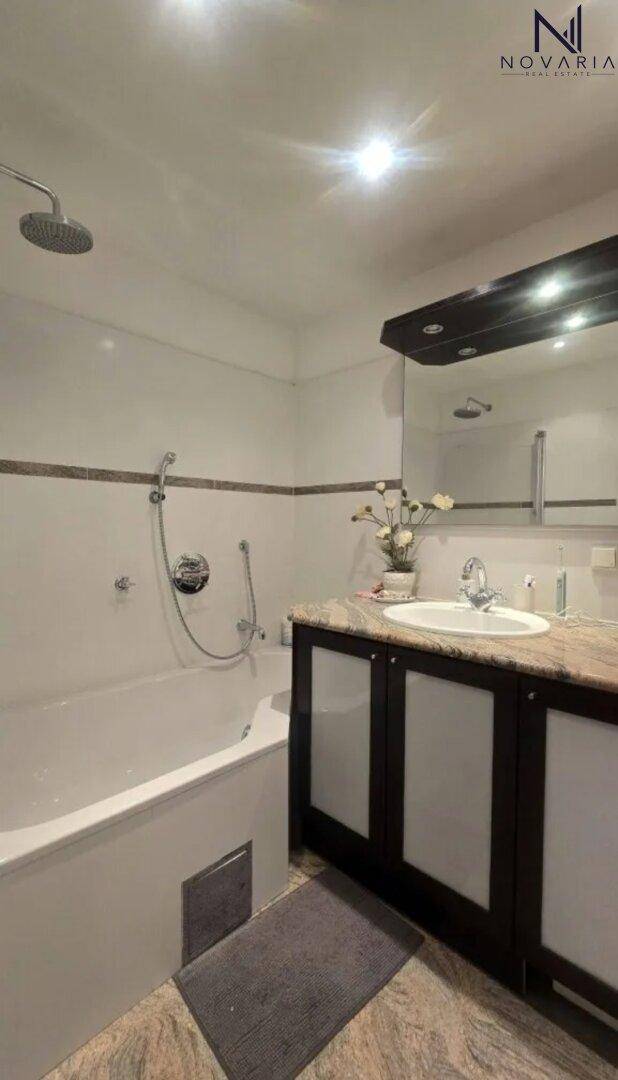 Modernes Badezimmer mit Badewanne, Regendusche und einem einzelnen Waschbecken.