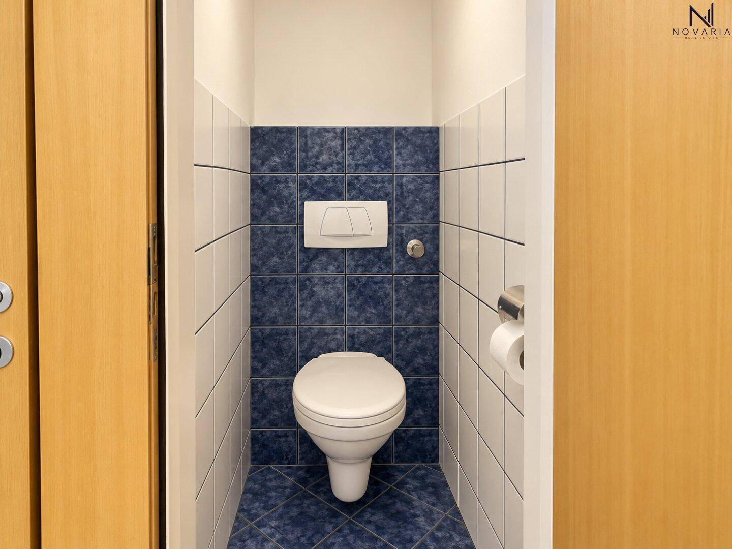 Separates WC mit Wand-WC und blauen Fliesen.