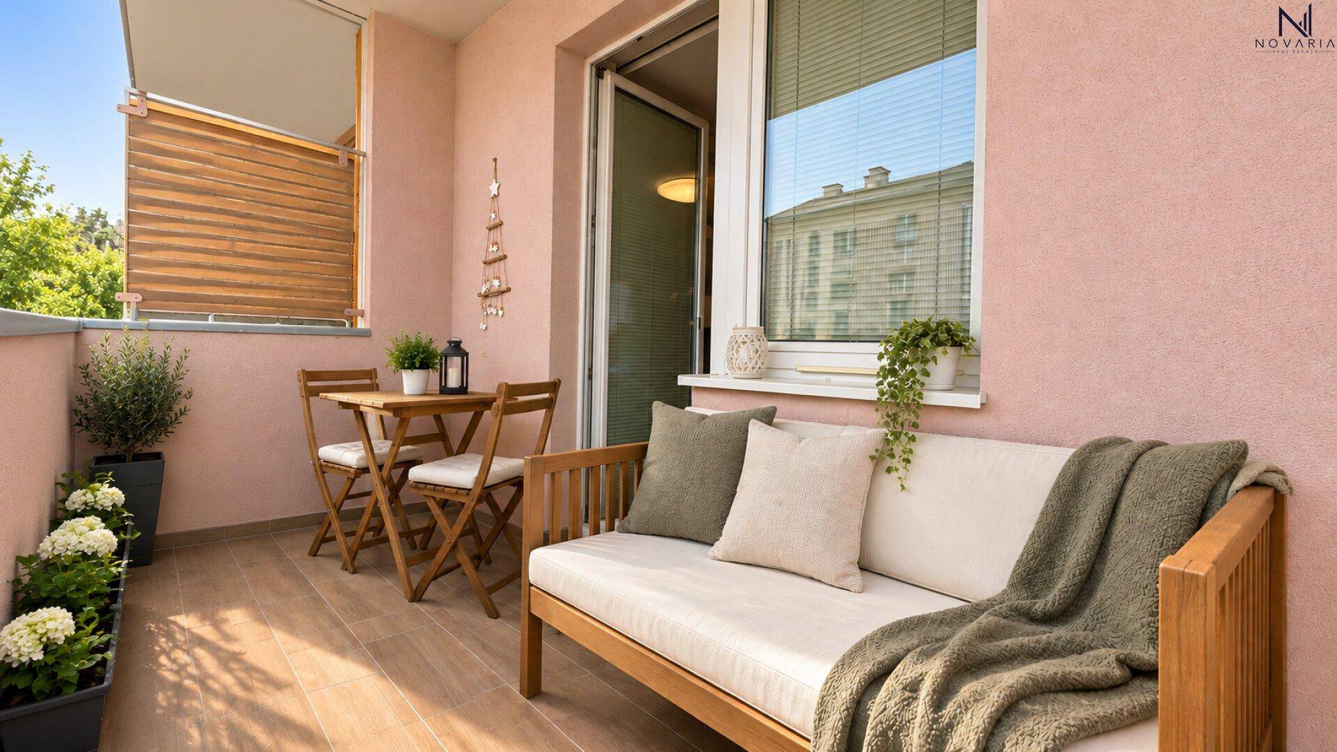 Möblierter Balkon mit Sitzgelegenheiten und Pflanzen.