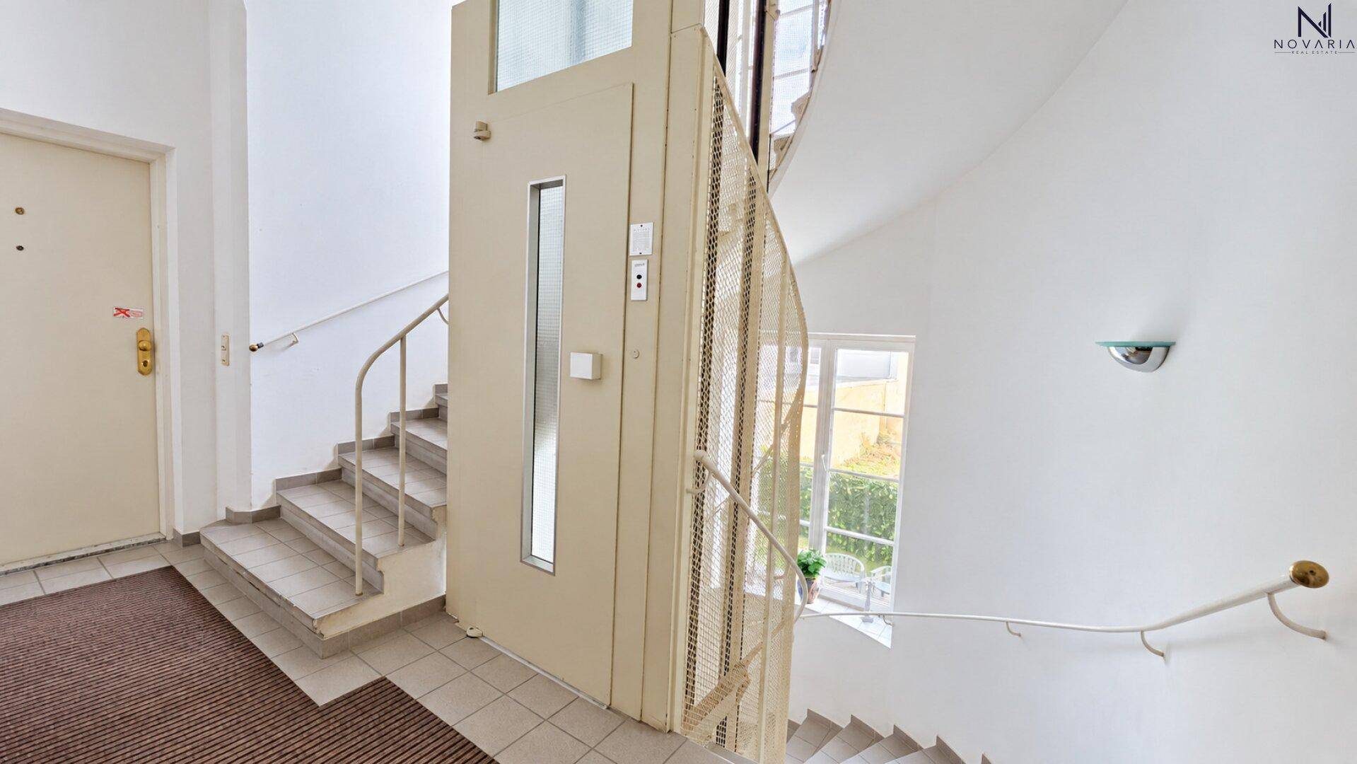 Treppenhaus mit integriertem Aufzug, der den Zugang zu den oberen Etagen erleichtert.