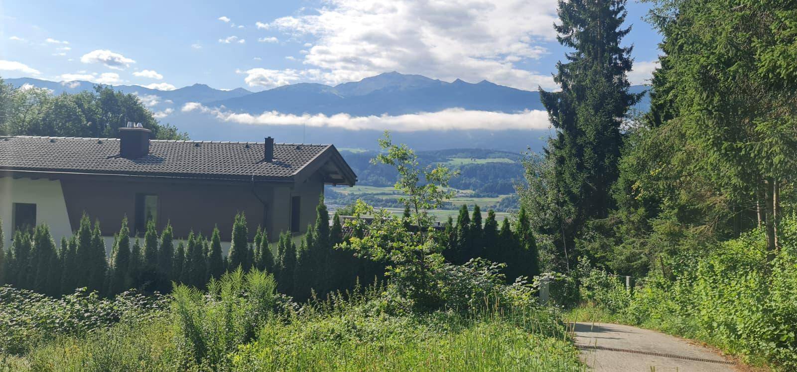 Wohnhaus umgeben von üppiger Vegetation mit Panoramablick auf die umliegende Berglandschaft.