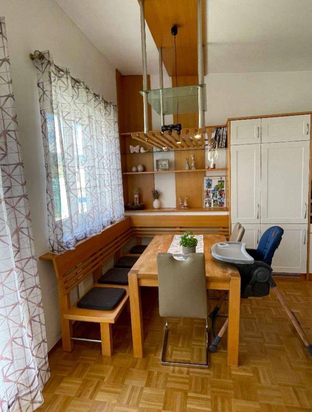 Gemütlicher Essbereich mit Holztisch und eingebauter Sitzbank, angrenzend an die Küche.